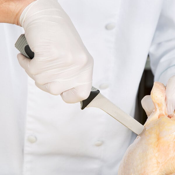 A person in white gloves using a Dexter-Russell V-Lo fillet knife to cut a chicken.