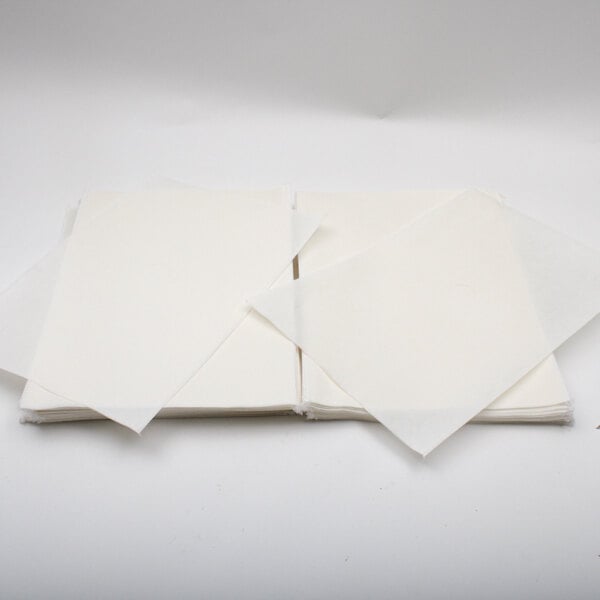 A stack of white Henny Penny filter paper sheets.