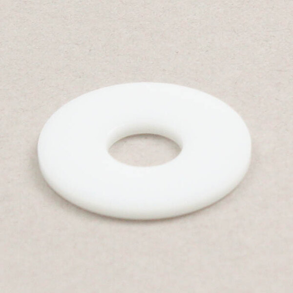 A white plastic washer with a hole in the center on a grey surface.