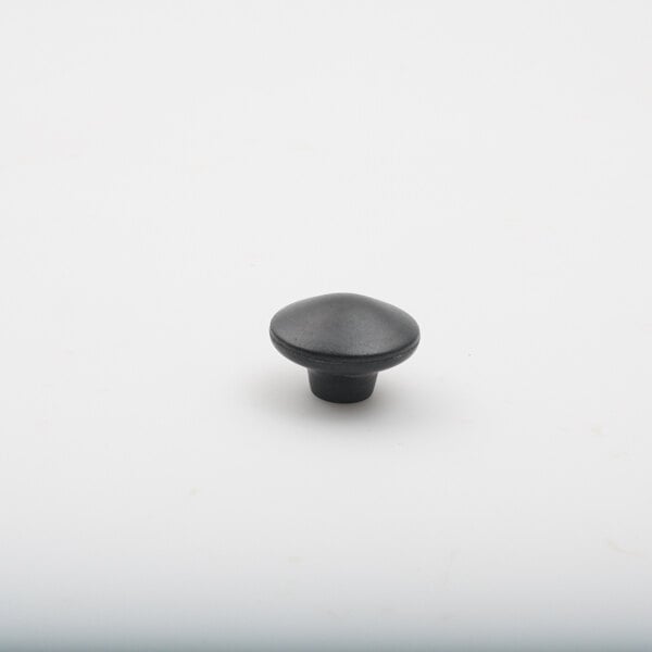 A black knob on a white surface.