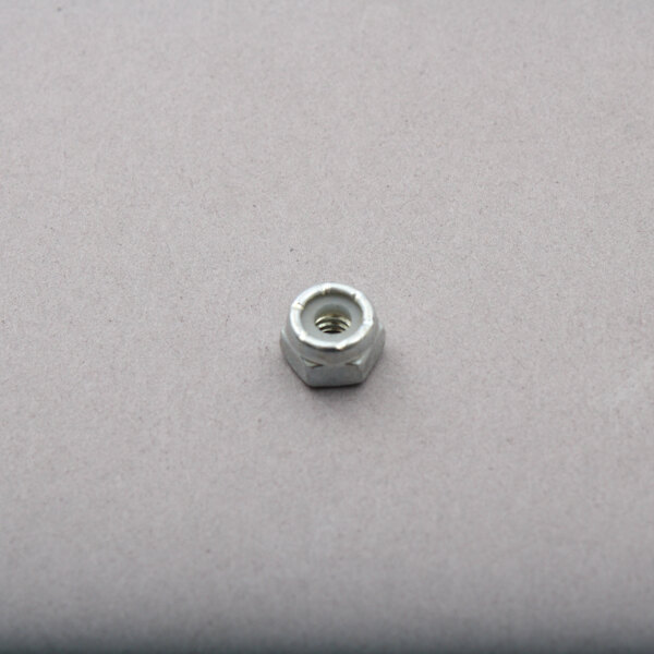 A small metal nut on a white surface.