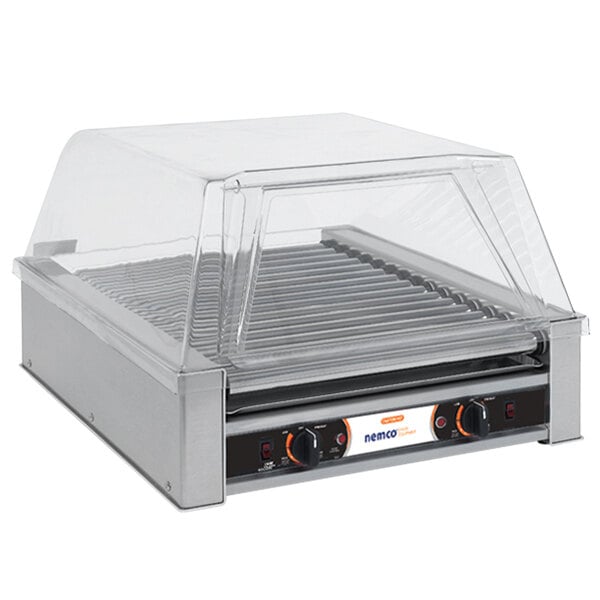 A Nemco hot dog roller grill on a counter with a clear cover.