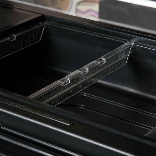 A clear plastic divider bar in a black container with a plastic tray.