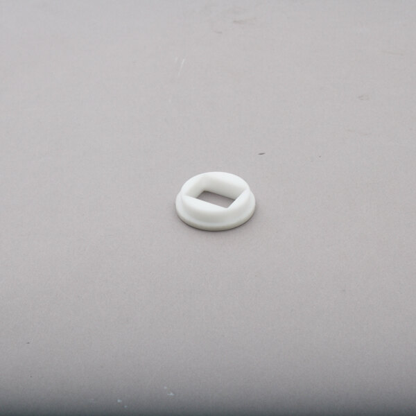 A white circular bushing with a square cut out.