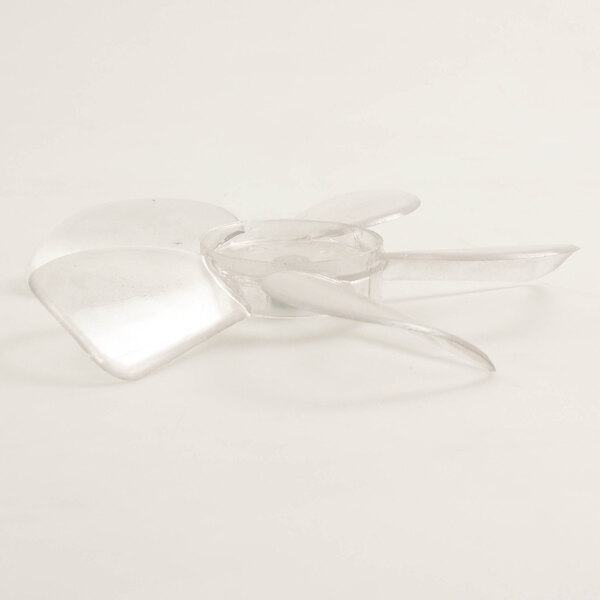 A clear plastic propeller for a Delfield refrigeration fan on a white surface.