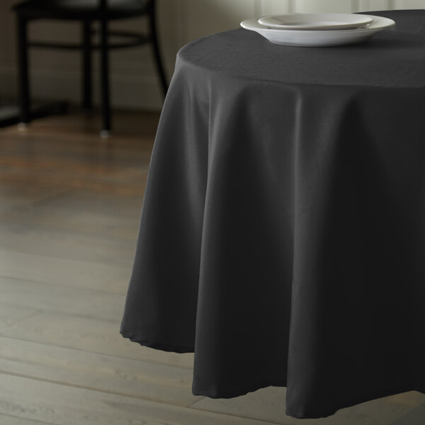 A table with an Intedge black tablecloth on it.