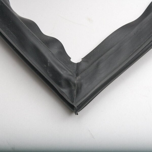 A black rubber Turbo Air Refrigeration door gasket corner with a small hole.