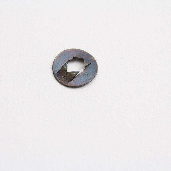 A close-up of a Cleveland Fastener, a small round metal object with a hole in it.