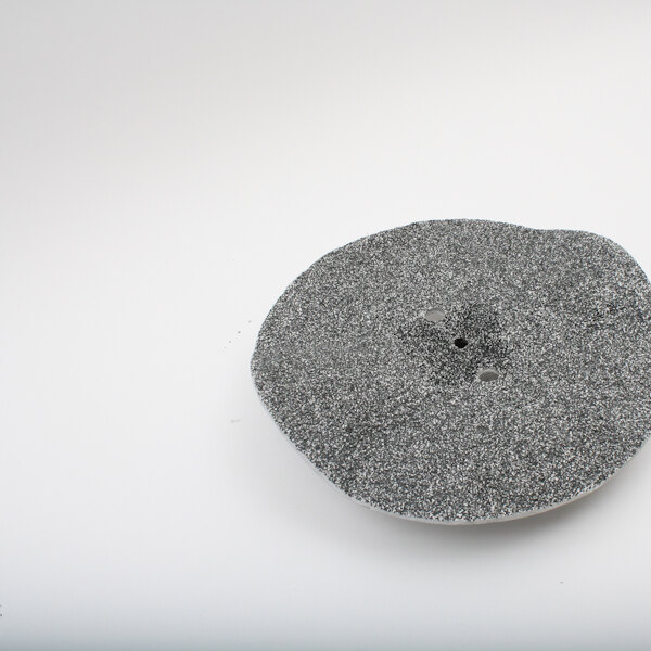 A grey Blakeslee peeler disk with holes in it.
