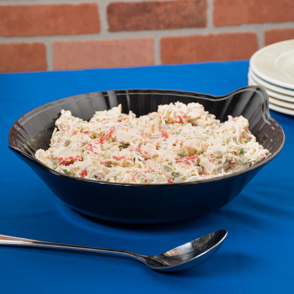 A black melamine bowl filled with crab salad on a table.