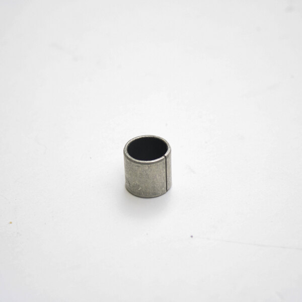 A small metal cylinder with a black circle on a white surface.