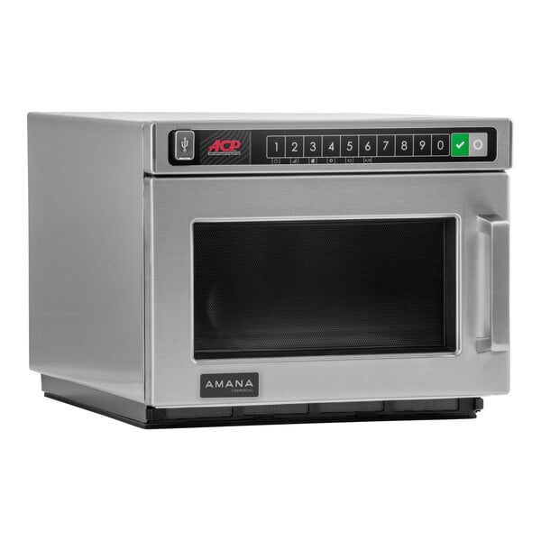 A stainless steel Amana commercial microwave on a counter.