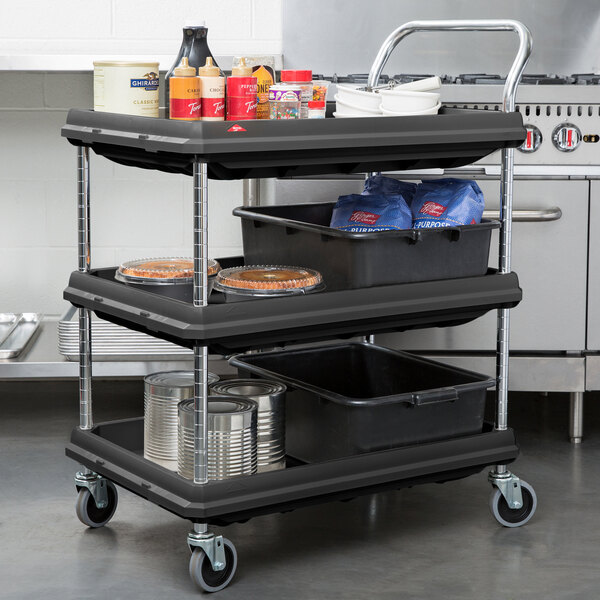 A black Metro utility cart with three deep ledge shelves holding food items.