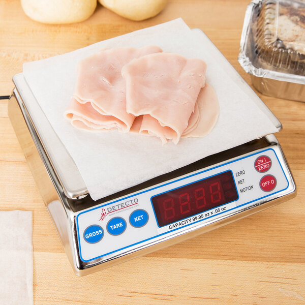 A Cardinal Detecto digital portion scale on a counter with meat on it.