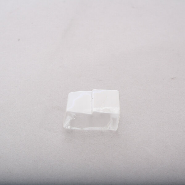 A white square plastic piece on a white surface.