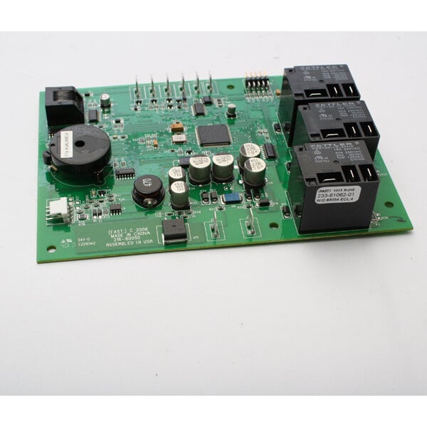 A Delfield commercial refrigeration control board with a green circuit board and small black and silver objects.