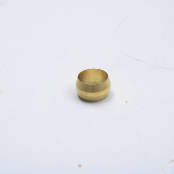 A gold round brass sleeve on a white surface.