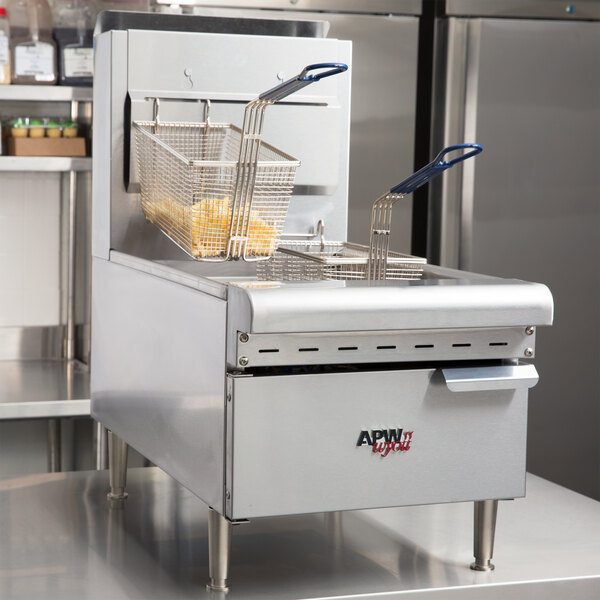 An APW Wyott liquid propane countertop gas fryer with baskets of fries on top.