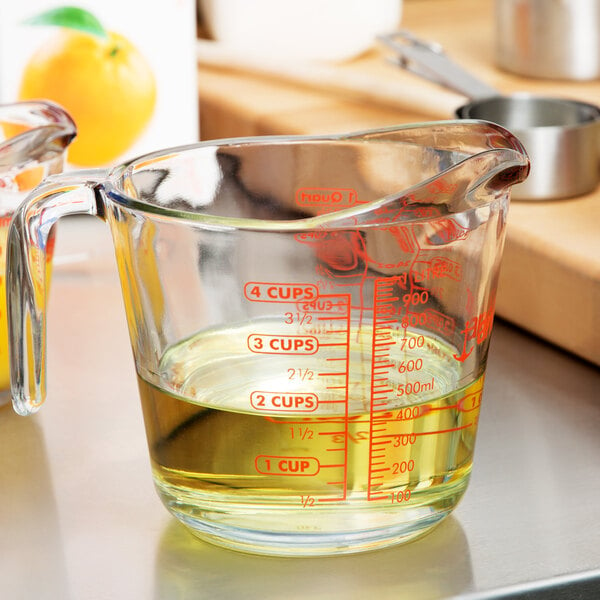 A clear Anchor Hocking glass measuring cup with yellow liquid inside.