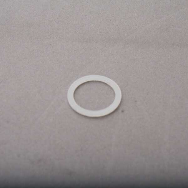 A white gasket with a white circle on a grey surface.