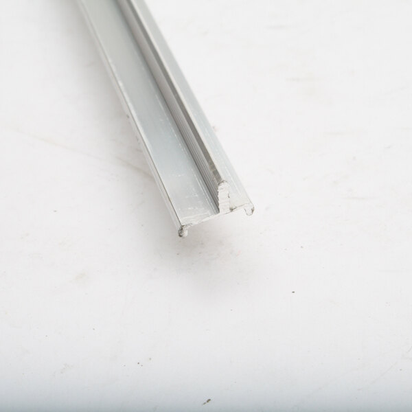 A Kolpak metal retainer bar on a white surface.