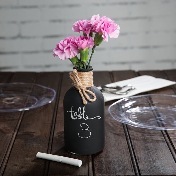 A Tablecraft round black chalkboard vase with a plant in it.