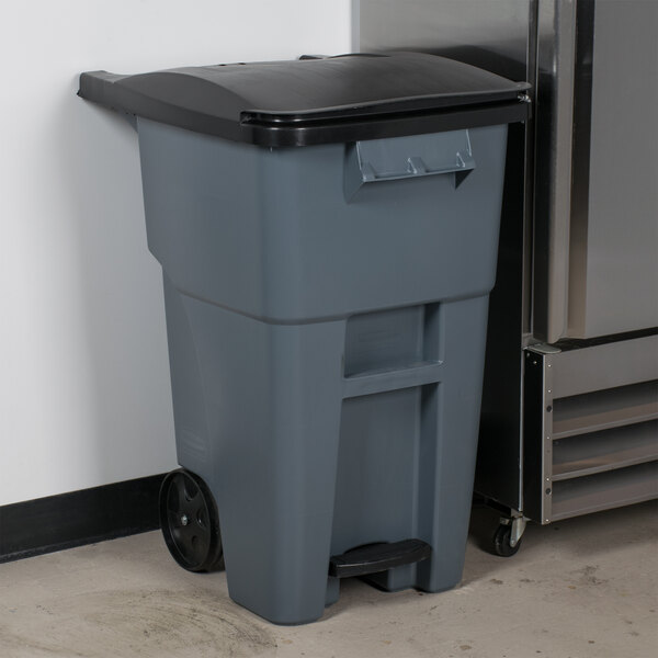 A Rubbermaid grey 50 gallon wheeled trash can with a lid.
