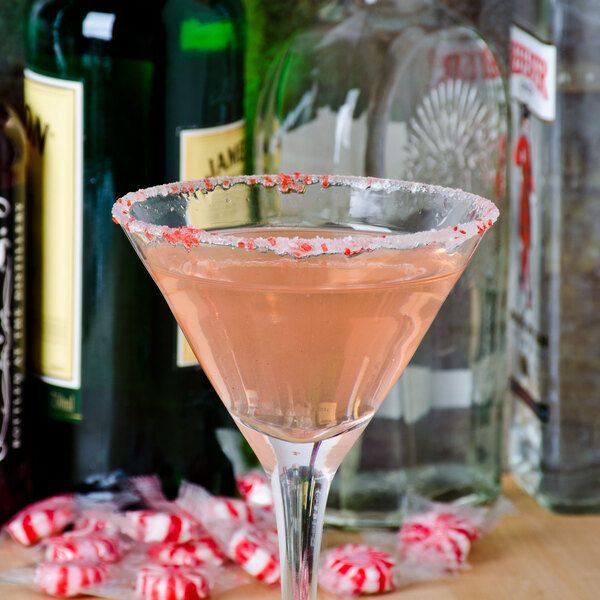 A Rokz peppermint candy cane rim on a pink cocktail in a martini glass.