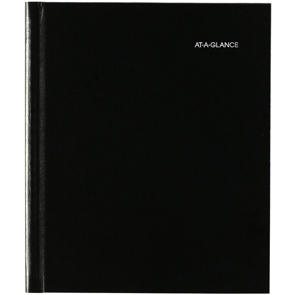 A black DayMinder hardcover monthly planner with white text on the cover.