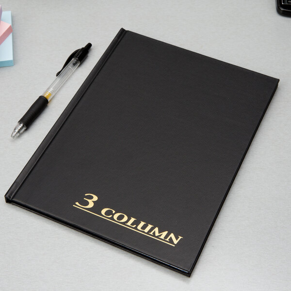 A black Adams Three Column account book with a pen on a white surface.
