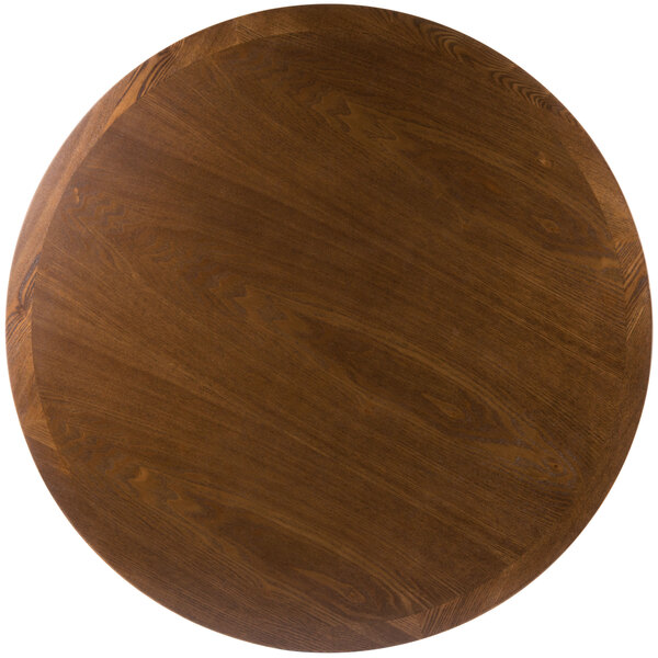 A BFM Seating round wooden table top with a dark wood finish.