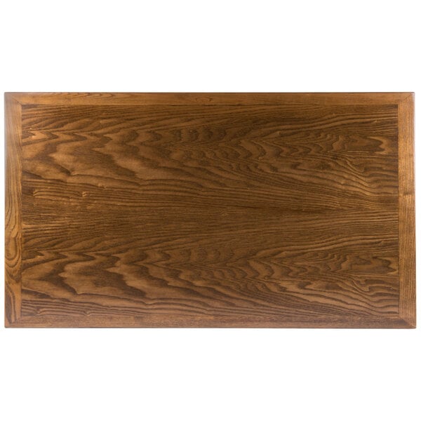 A rectangular BFM Seating wooden table top with a dark wood finish.