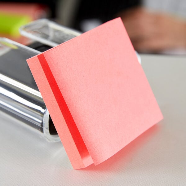 A fan-folded stack of 3M Post-It notes in neon colors.