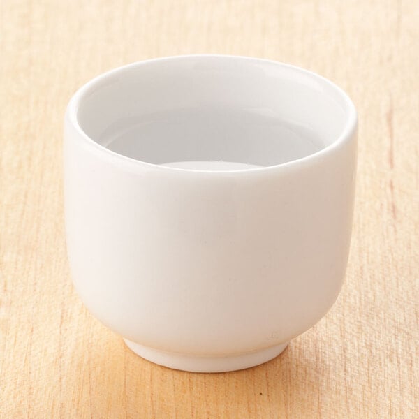 A white Town ceramic sake cup filled with liquid.