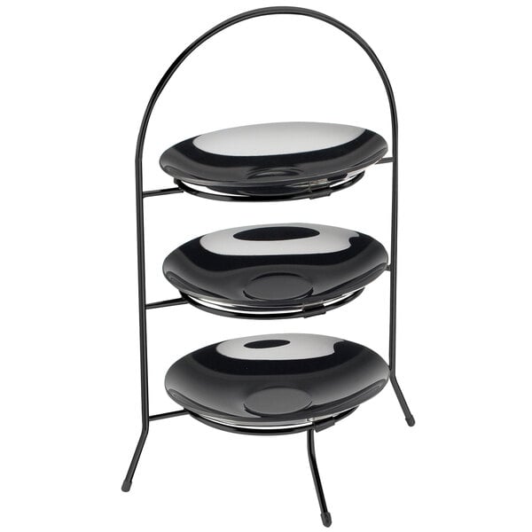 A black metal three tiered bowl and plate display stand with round tops.