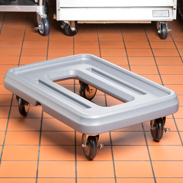 A Metro Mightylite Pan Carrier Dolly with metal wheels on a tile floor.