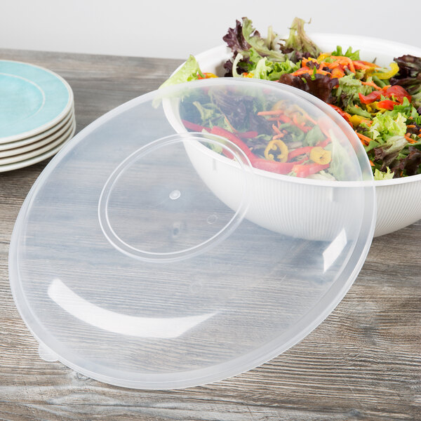 A clear plastic Fineline lid on a bowl of salad.