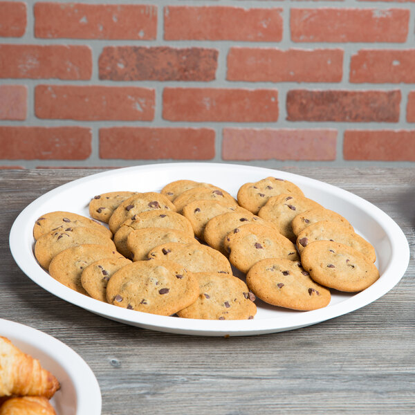 A white Fineline plastic catering tray holding cookies and croissants on a table.