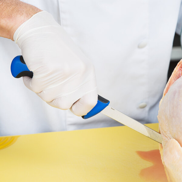 A hand in a white glove holding a blue Mercer Culinary boning knife.