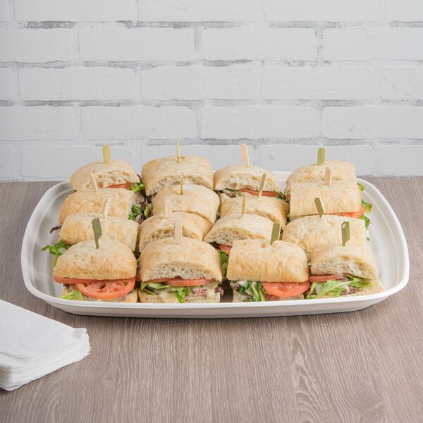 A tray of sandwiches on a white Eco-Products compostable sugarcane tray.