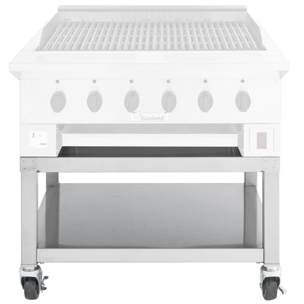 A Garland stainless steel equipment stand with casters holding a white gas grill.
