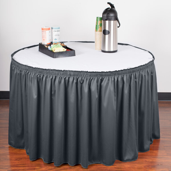 A table with a slate blue Snap Drape table skirt on it and a tray of food.