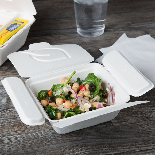 A salad in an Eco-Products Folia takeout container with a fork and a napkin.