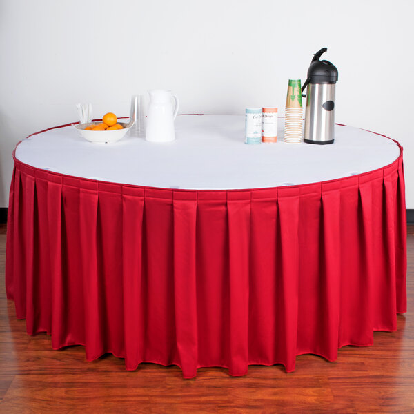 A table with a Snap Drape red box pleat table skirt on it.
