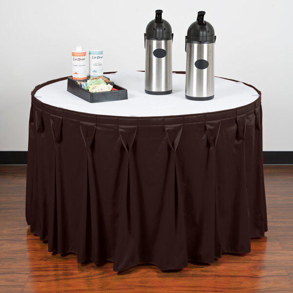 A table with a brown Snap Drape table skirt and a tray of food.