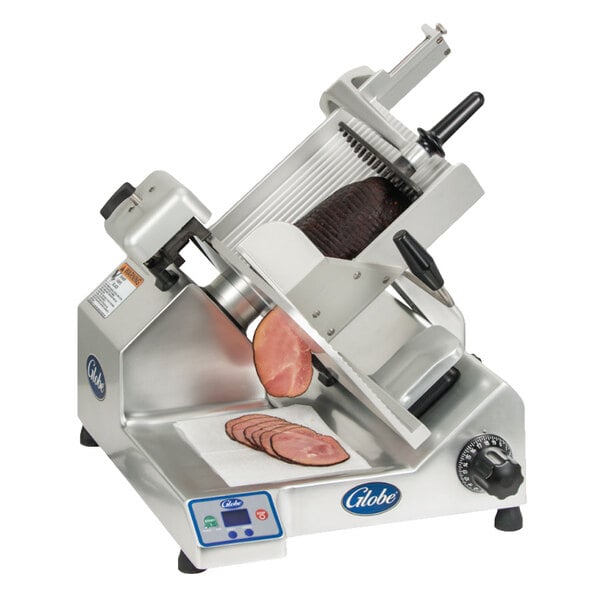 A Globe manual meat slicer slicing ham.