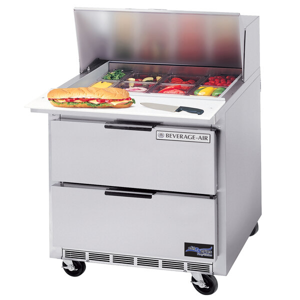A Beverage-Air stainless steel refrigerated sandwich prep table with trays of sandwiches.