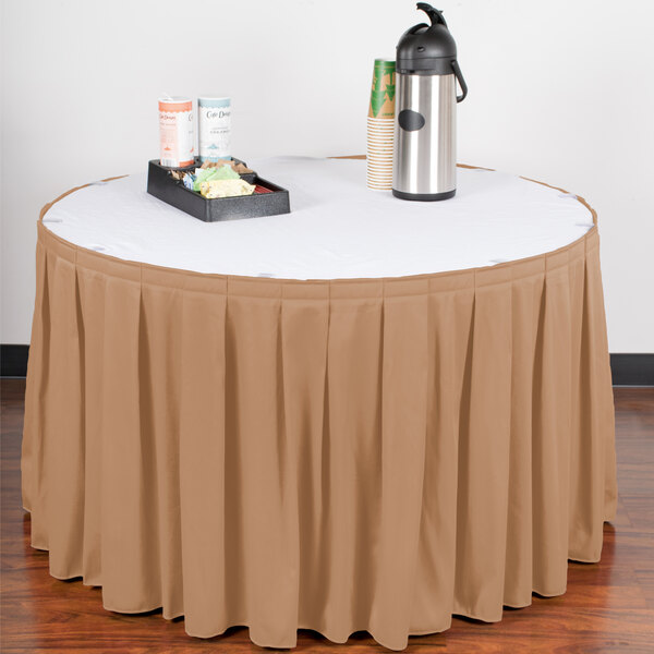 A Snap Drape sandalwood box pleat table skirt on a table with a tray of drinks.
