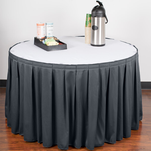 A table with a slate blue Snap Drape box pleat table skirt with Velcro clips.
