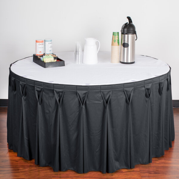 A table with a slate blue Snap Drape Wyndham table skirt on it.